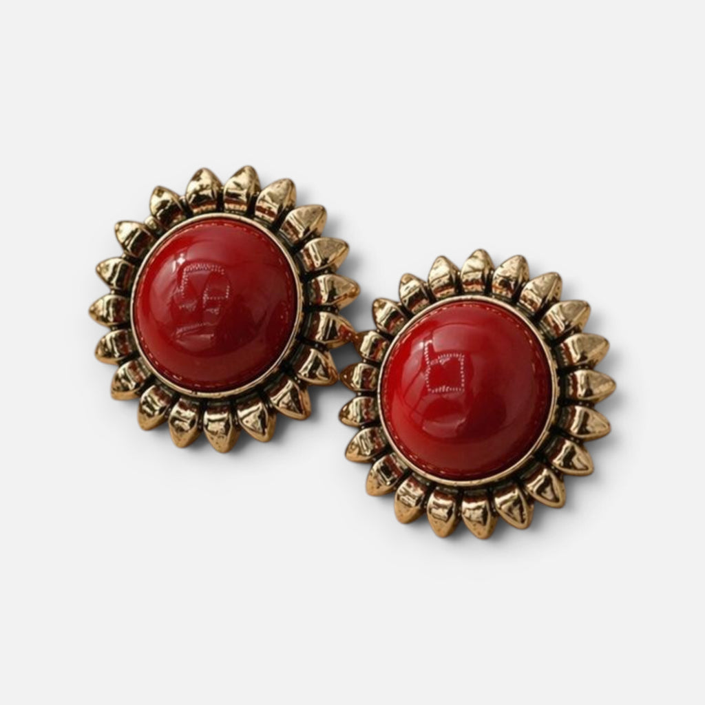 Jakris red sun earrings featuring a polished red cabochon center surrounded by a gold-toned sunburst petal frame.