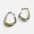 Jakris sculptural gold teardrop hoop earrings with a modern, asymmetrical design and polished finish.