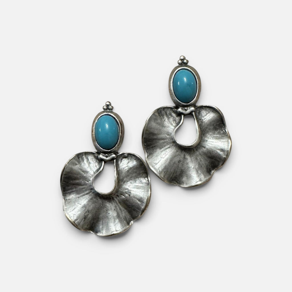 Jakris silver-plated brass statement earrings featuring organic ruffled shapes and vibrant blue oval stones.