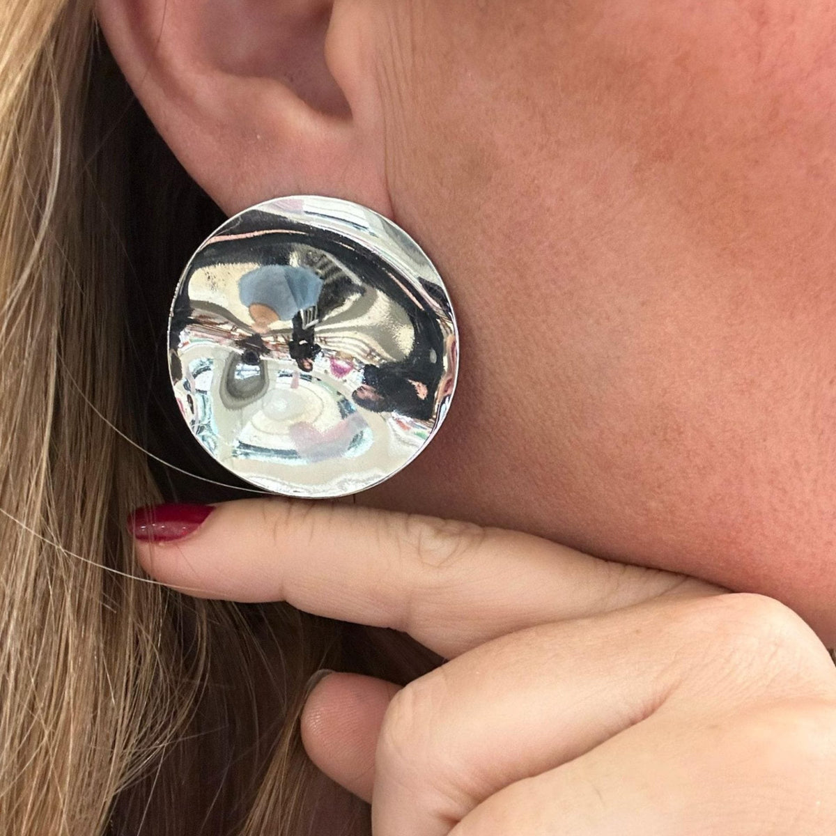 Jakris silver-toned circular mirror-finish statement earrings worn on a model