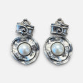 Jakris silver-tone earrings featuring a hammered metal design with a central white pearl and scroll-top detail