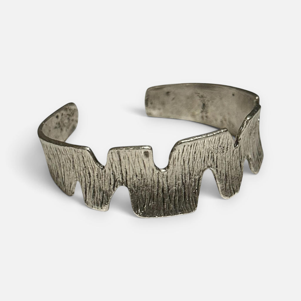 Jakris handmade silver plated cuff bracelet with a textured zig-zag pattern on a white surface