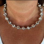 Jakris silver tone choker necklace featuring large clear faceted stones and polished metal beads worn on a neck