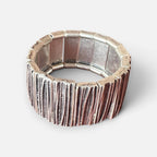 Jakris silver-toned elastic wide bracelet with a textured, rustic finish on a neutral background.