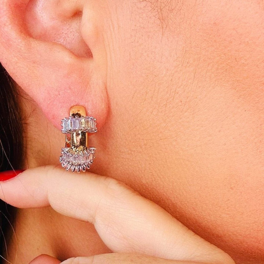 Jakris small gold hoop earrings with baguette and round cut sparkling stones worn on a woman's earlobe