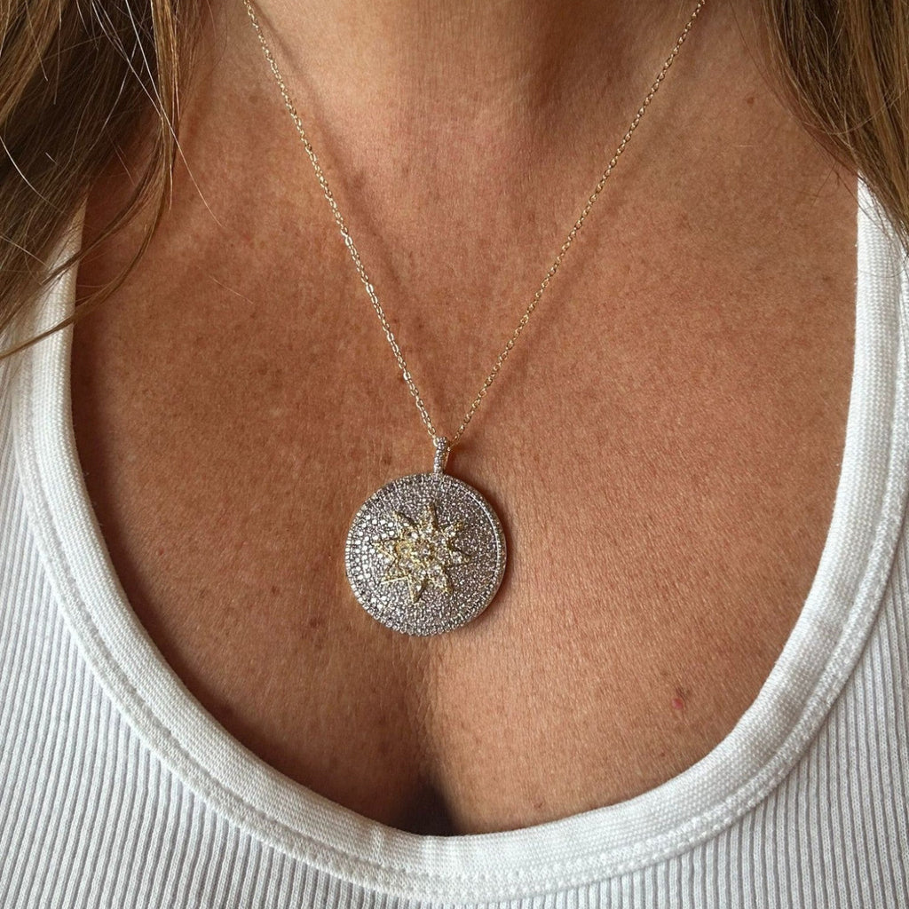 Jakris round pendant necklace featuring a star motif with sparkling white and yellow zircon stones on a gold chain.