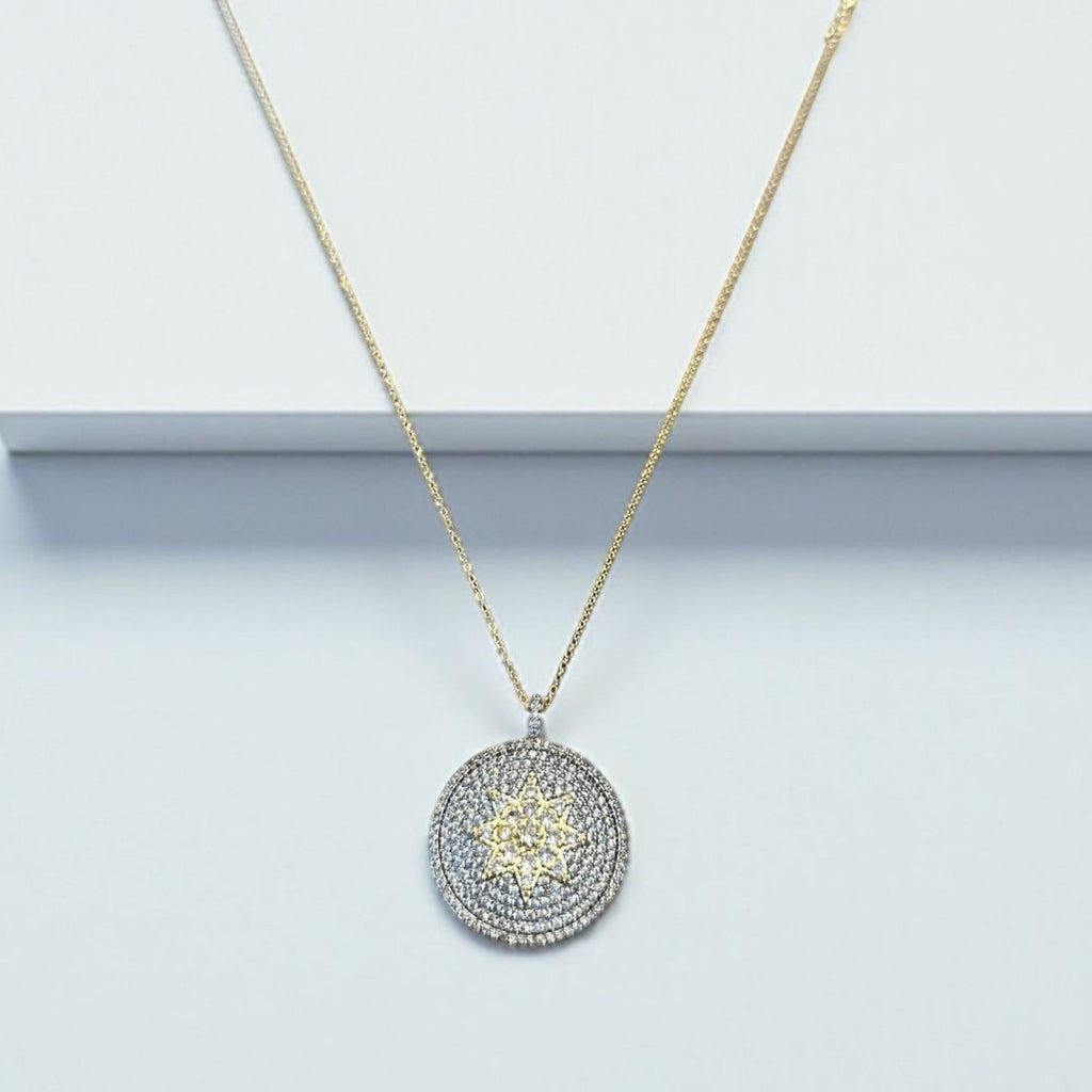 Jakris round pendant necklace featuring a central star motif encrusted with sparkling white and yellow zircon stones.