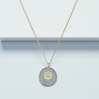 Jakris round pendant necklace featuring a central star motif encrusted with sparkling white and yellow zircon stones.