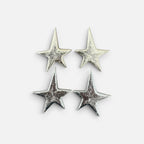 Jakris silver star-shaped earrings with a textured metallic finish displayed on a plain white background.