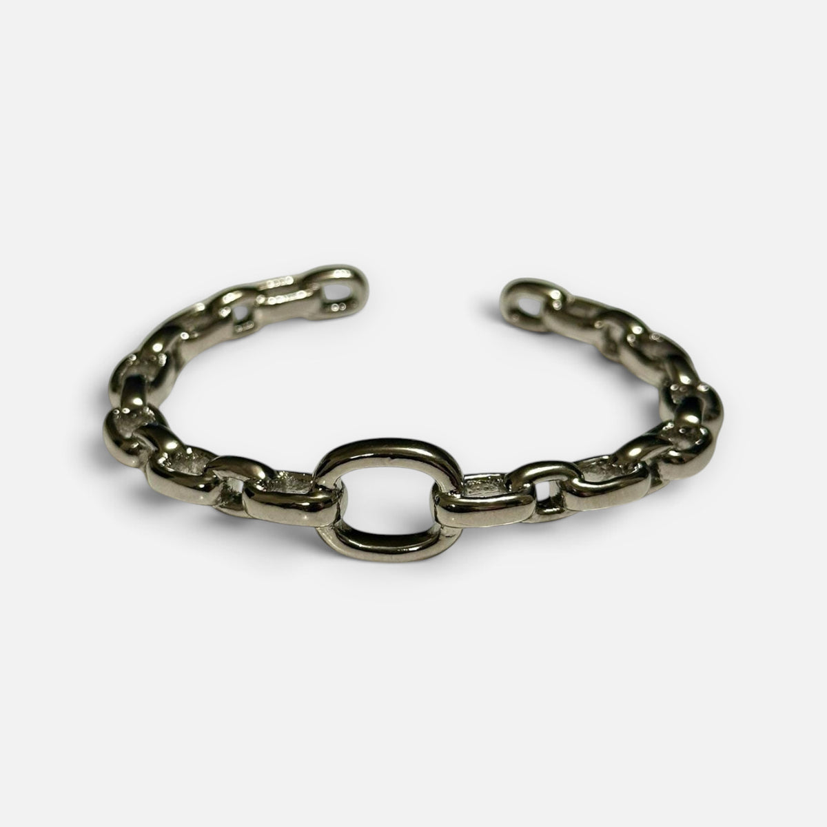 Jakris thick silver chain cuff bracelet with an open link design on a white background