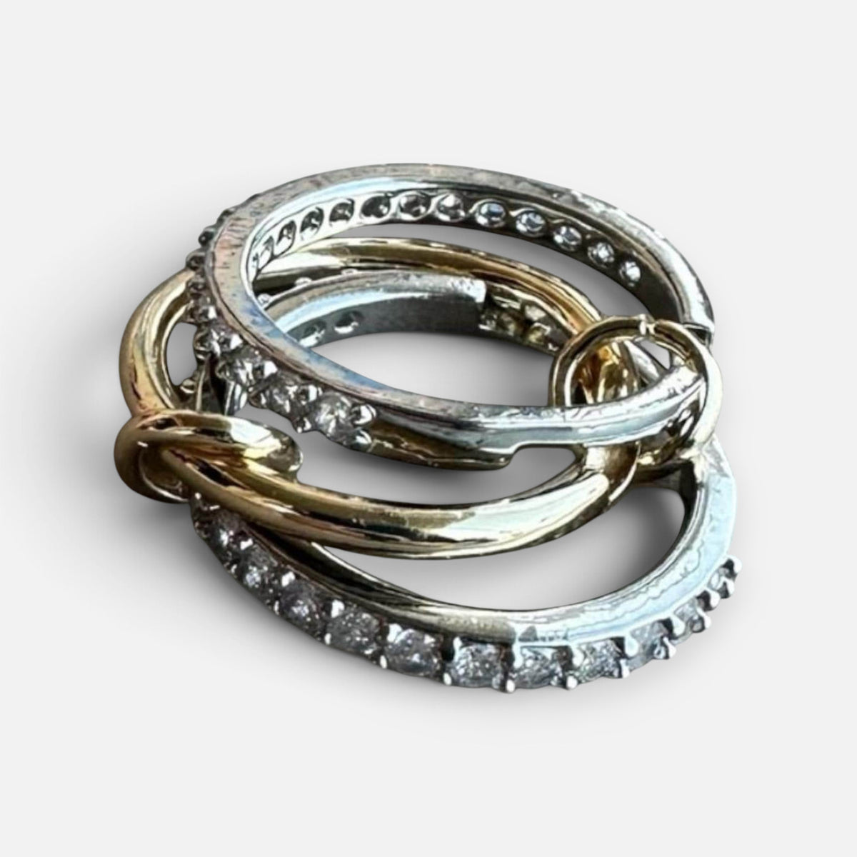 Jakris three-band ring featuring mixed gold and silver tones with sparkling zircon stones in a stacked design.