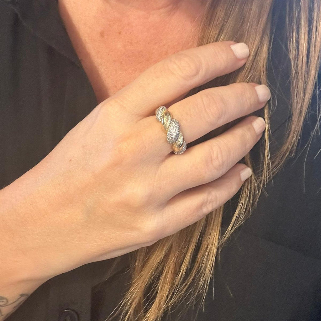 Jakris twisted gold ring with sparkling zircon stones worn on a woman's finger