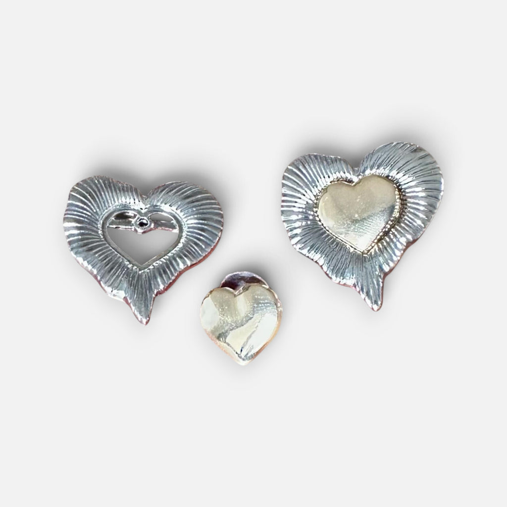 Jakris vintage style two-piece detachable silver heart earrings with textured radiating lines on a marble surface