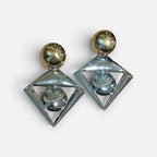 Jakris geometric statement earrings featuring a two-tone gold and silver design with diamond and sphere shapes.