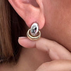 Jakris vintage two-tone shield dangle earrings in silver and gold worn on an earlobe