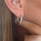 Jakris two-tone gold and silver hoop earring featuring sparkling zircon stones worn on an earlobe