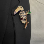 Jakris vintage enamel toucan bird brooch with colorful tropical details pinned on a black blazer lapel