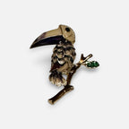 Jakris vintage enamel toucan bird brooch featuring tropical colors and a green leaf detail on a branch