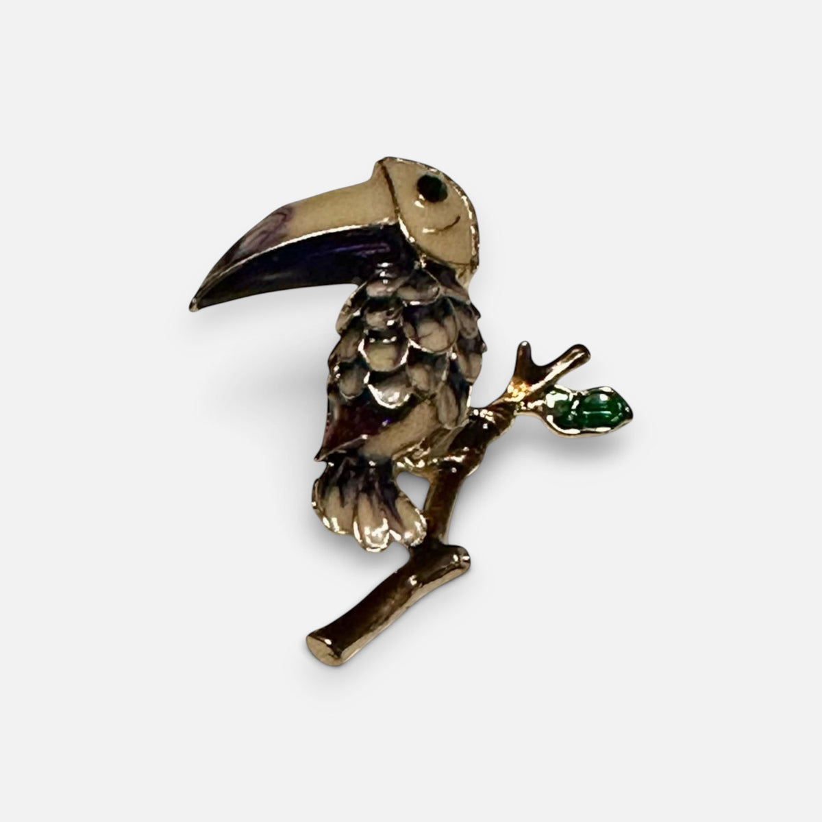 Jakris vintage enamel toucan bird brooch featuring tropical colors and a green leaf detail on a branch