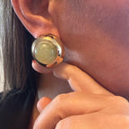 Jakris vintage round earring featuring a smooth green stone set in a polished gold-tone metal frame on an earlobe.