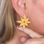 Jakris yellow enamel flower stud earrings worn on earlobe with gold-tone metal detailing
