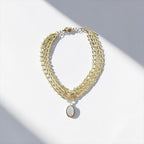 Jakris Zafira gold-plated multi-strand braided chain necklace with a central oval stone-encrusted pendant