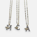 Jakris gold-tone chain necklaces featuring letter pendants M, C, and A adorned with sparkling zircon and bee charms.