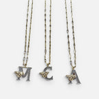 Jakris gold-tone chain necklaces featuring letter pendants M, C, and A adorned with sparkling zircon and bee charms.