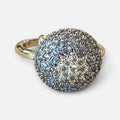 Jakris gold ring featuring a large circular top encrusted with sparkling zircon stones and a star pattern design.