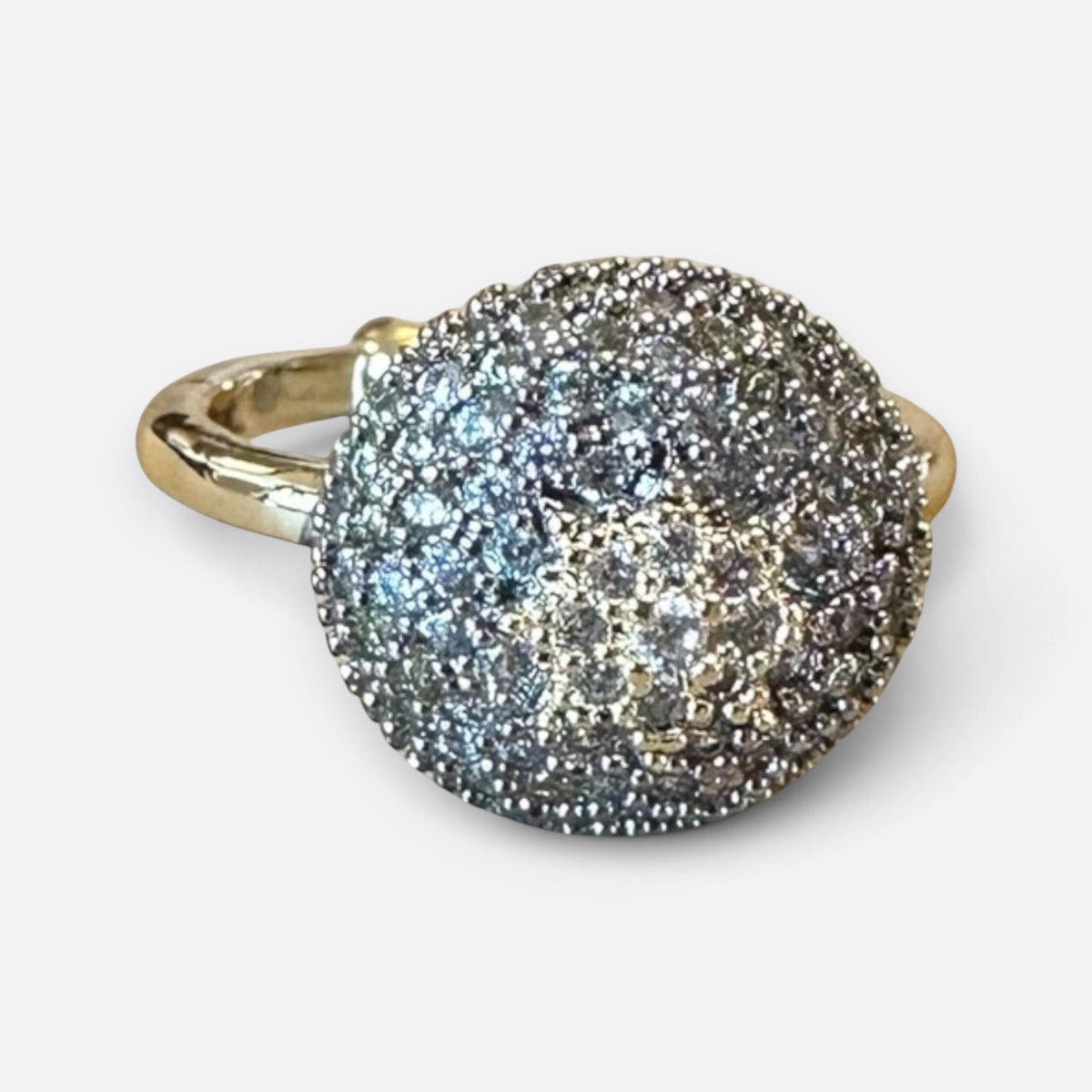Jakris gold ring featuring a large circular top encrusted with sparkling zircon stones and a star pattern design.